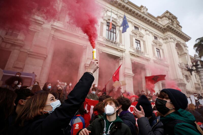High school students light flares as they gather to protest against online schooling outside the Ministry of Education, in Rome, Italy. AP Photo