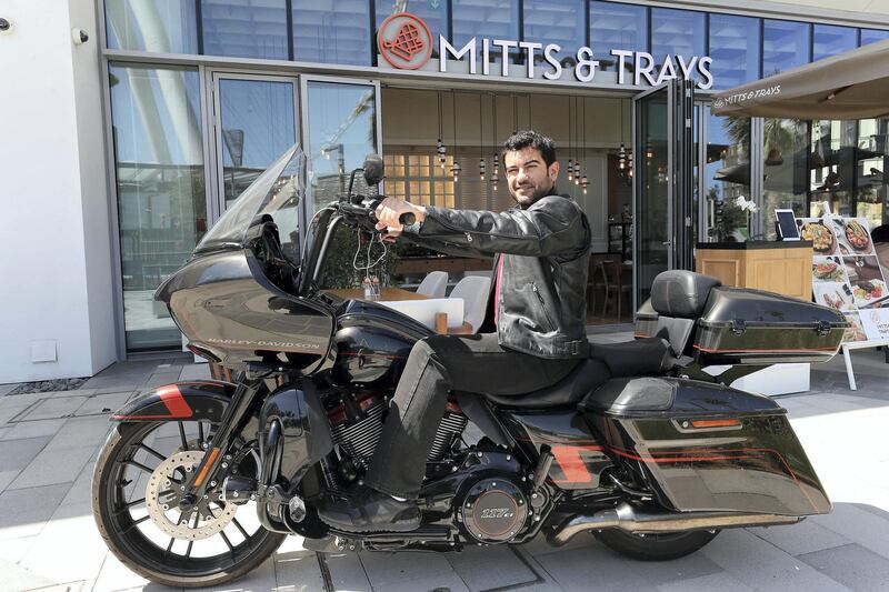 DUBAI , UNITED ARAB EMIRATES , March 5 – 2019 :- Yousef Al Rostamani, owner of Mitts & Trays restaurants with his Harley Davidson motorcycle outside the restaurant at the Bluewaters Island in Dubai. ( Pawan Singh / The National ) For Business. Story by Nada El Sawy
