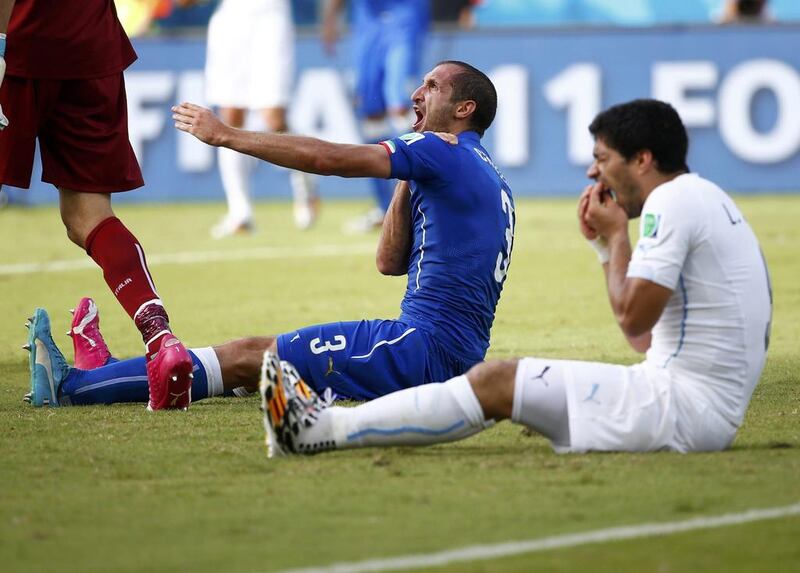 Uruguay's Luis Suarez, right, reacts after clashing with Italy's Giorgio Chiellini, appearing to bite him on the shoulder, during their match on Tuesday at the 2014 World Cup. Tony Gentile / Reuters / June 24, 2014  