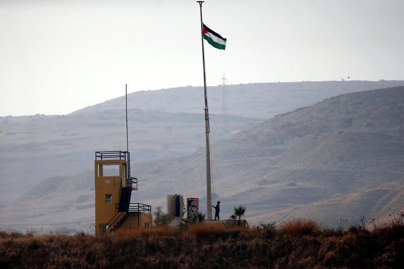 A Jordanian soldier pulls a Jordanian national flag in an outpost at the border area between Israel and Jordan at Naharayim, as seen from the Israeli side. Reuters