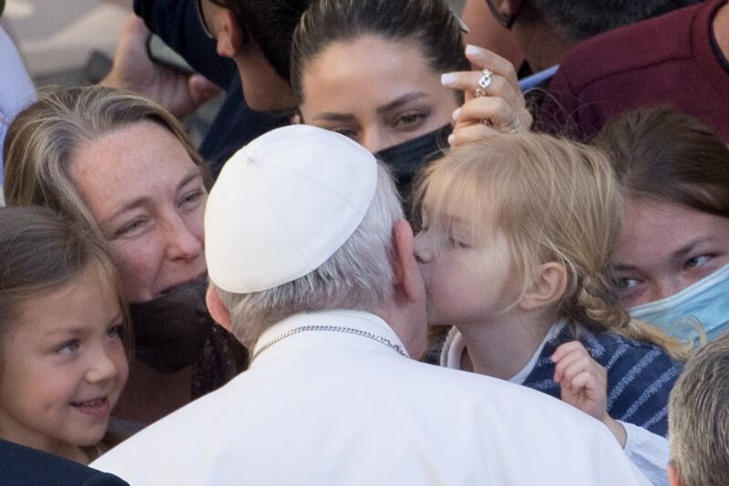 Pope Francis receives a kiss as he arrives at the San Damaso courtyard for the weekly general audience at the Vatican. Reuters