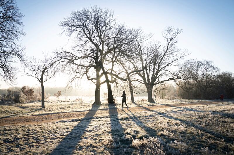 A jogger runs through a frost-covered landscape in Wanstead Park in north-east London on Thursday, after a night of low temperatures in the capital.  AP