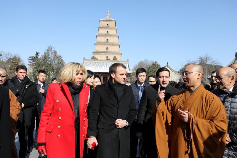 French President Emmanuel Macron and his wife Brigitte Macron listen to a priest during a visit at the Big Wild Goose Pagoda in the northern Chinese city of Xian, Shaanxi province, China January 8, 2018. REUTERS/Ludovic Marin/Pool