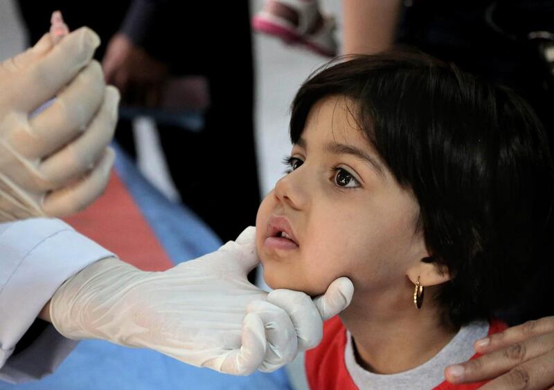 An Iraqi doctor gives a polio vaccine to a young girl in Baghdad, Iraq.  Khalid Mohammed / AP Photo