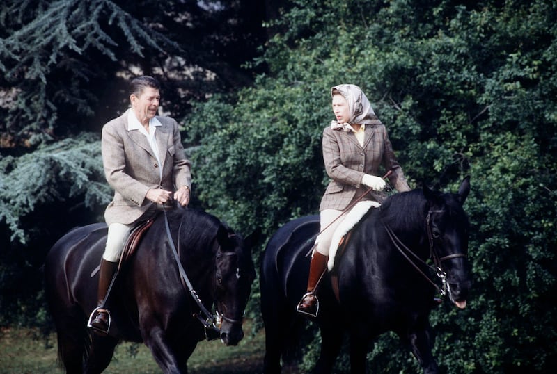 Queen Elizabeth II rides her horse Burmese, with then US president Ronald Reagan on Centennial, on the grounds of Windsor Castle, on June 8, 1982. Getty Images