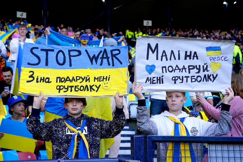 Ukraine fans hold up anti-war signs before a Fifa World Cup qualifier match at Hampden Park, Glasgow. PA