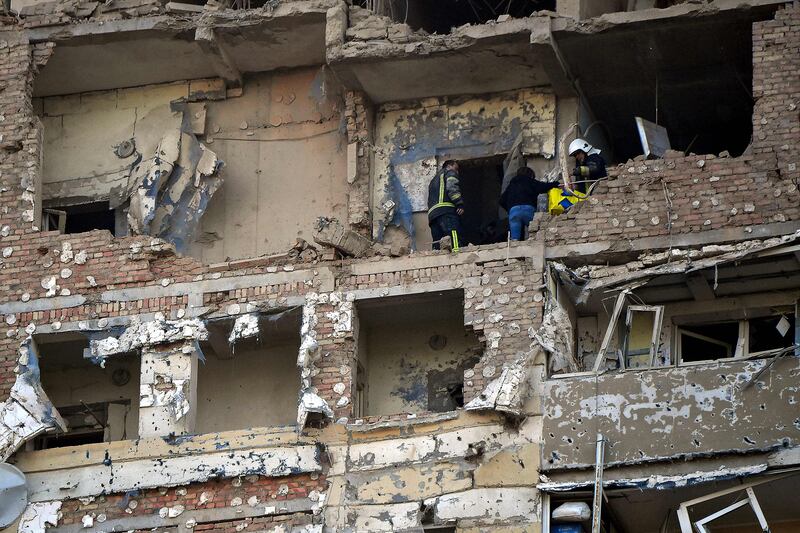 Rescuers evacuate a woman in a multi-storey residential building after it was partially destroyed in a Russian drone attack. AFP