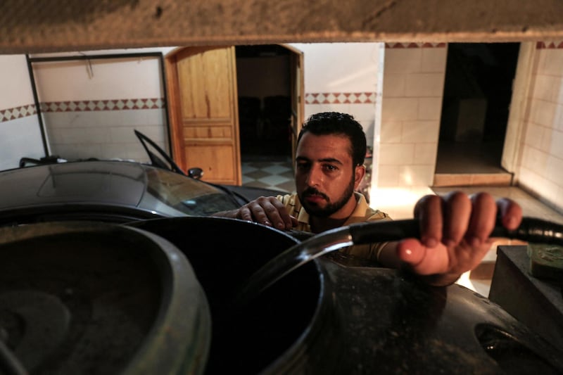 A Palestinian man fills water tanks during the few hours of mains electricity supply their house receives every day, on July 22, 2017, at Rafah refugee camp in the southern Gaza Strip. - Power supplies have taken a fresh hit in the Hamas-run Gaza Strip, with authorities on July 8 accusing the rival Palestinian Authority of blocking fuel payments to Egypt from going through banks. The electricity distribution company confirmed only one generator was operating, producing 23 megawatts of power -- which added to other sources means Gaza currently has a total of 93 megawatts a day. More than 500 megawatts are required to serve the Palestinian enclave's population. (Photo by SAID KHATIB / AFP)