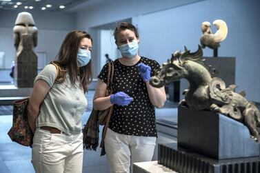 Abu Dhabi, United Arab Emirates, June 25, 2020. Museum visitors talk about the Winged dragon, Dragon aile, Warring State period, Northern China, 475-221 BCE, Bronze. Victor Besa / The National Section: NA Reporter: Saeed Saeed