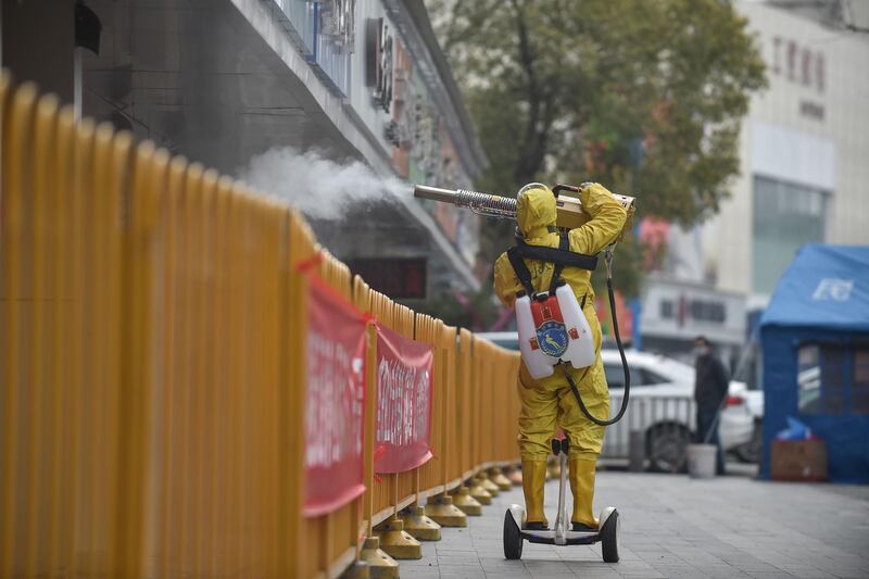 A medical staff member sprays disinfectant at a residential area in Wuhan in China's central Hubei province.  AFP