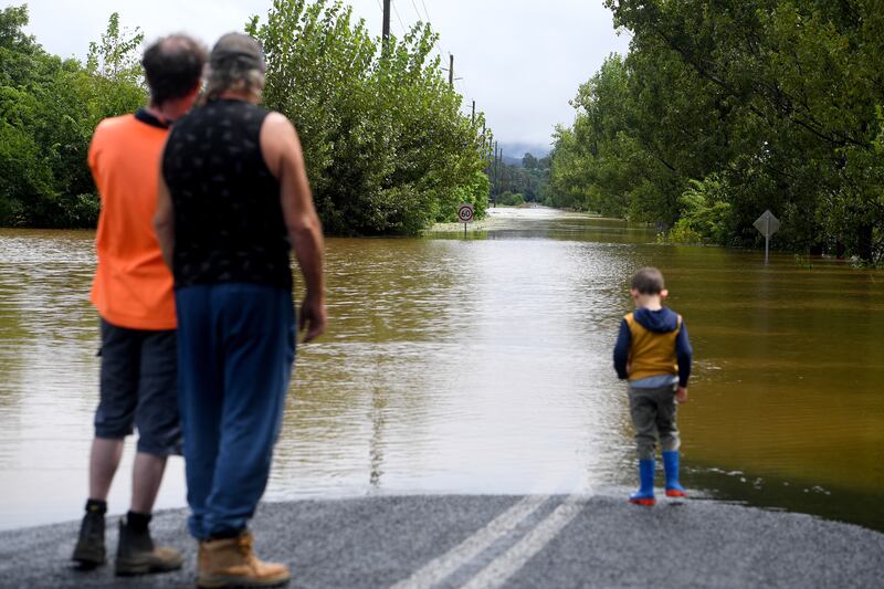 People look at a road cut off by floodwater at Richmond, north west of Sydney, New South Wales. EPA