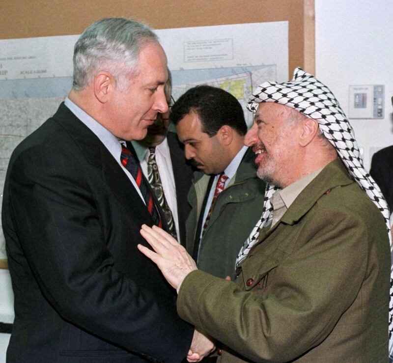 Israeli Prime Minister Benjamin Netanyahu, (L), shakes hands with a smiling Palestinian Authority President Yasser Arafat, (R), at a meeting at Erez crossing between Israel and the Gaza Strip Wednesday Jan 15, 1997. Israel and the PLO concluded a long-elusive agreement on Wednesday extending Palestinian rule to Hebron in the West Bank.