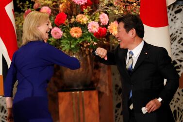 Britain's international trade secretary Liz Truss and Japan’s Foreign Minister Toshimitsu Motegi bump elbows during their news conference following a signing ceremony of the UK-Japan trade agreement in Tokyo on Friday. Reuters
