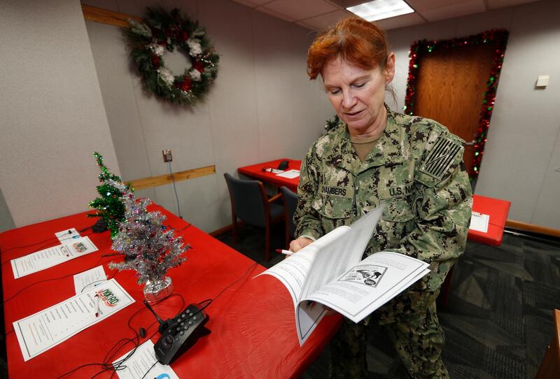 United States Navy Specialist Petty Officer 1st Class Shannon Chambers of Long Beach, Calif., looks over a volunteer playbook in the NORAD Tracks Santa centre at Peterson Air Force Base. AP