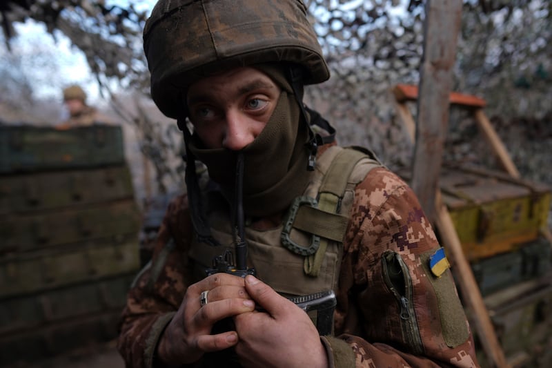 A Ukrainian soldier speaks on a walkie-talkie at his position at the line of separation between Ukraine-held territory and rebel-held territory near Svitlodarsk, eastern Ukraine. AP