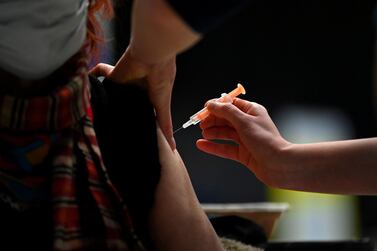 A patient receives an injection of the Oxford/AstraZeneca Covid-19 vaccine at the vaccination centre set up inside Brighton Centre in Brighton. AFP