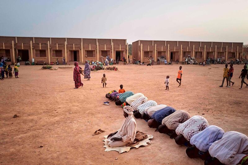 Displaced men worship in a courtyard in Sevare in central Mali, on February 26, 2020. Two months earlier 400 Dogon people fled their village of Toou finding a shelter in a school of Sevare. AFP