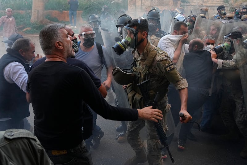Retired members of the Lebanese security forces and other protesters scuffle with Lebanese soldiers during a protest in Beirut demanding better pay and living conditions. AP 