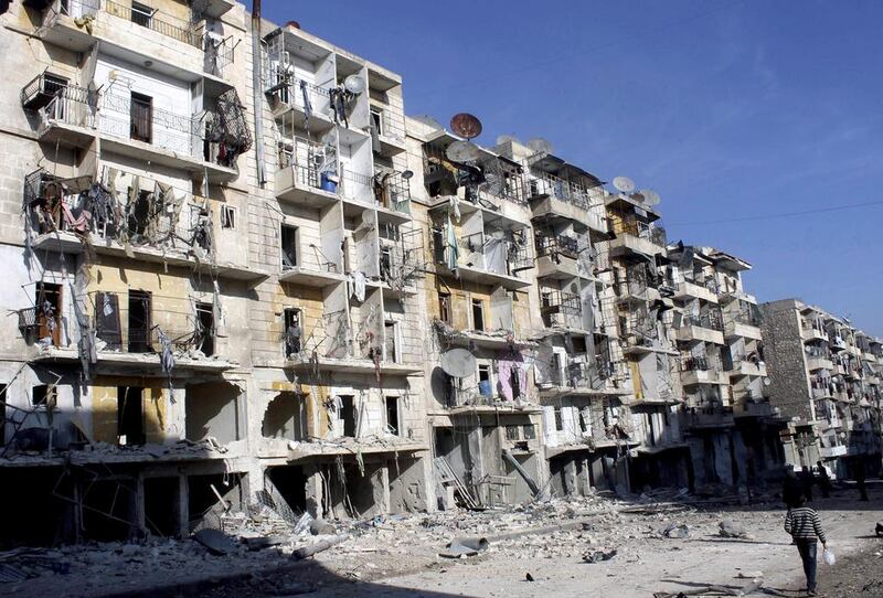 People walk past buildings damaged by what activists said was barrel bombs dropped by government forces in Aleppo's Dahret Awwad neighborhood on January 24, 2014. Hosam Katan/Reuters