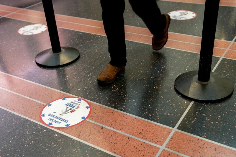 A traveler walks near a social distancing marker in a security line at Ronald Reagan National Airport (DCA) in Arlington, Virginia, U.S., on Tuesday, May 25, 2021. AAA Travel's Memorial Day forecast said more than 37 million people are expected to travel 50 miles or more for the holiday weekend, an increase of 60% from last year compared to last year's record low. Photographer: Stefani Reynolds/Bloomberg