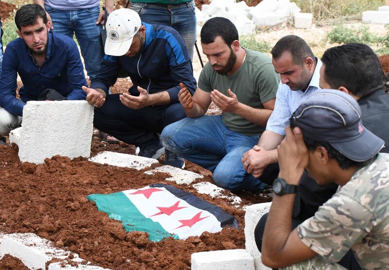 Syrian mourners prayer over the grave of late rebel fighter Abdel-Basset al-Sarout just after his burial in al-Dana in Syria's rebel-controlled Idlib region, near the border with Turkey. AFP