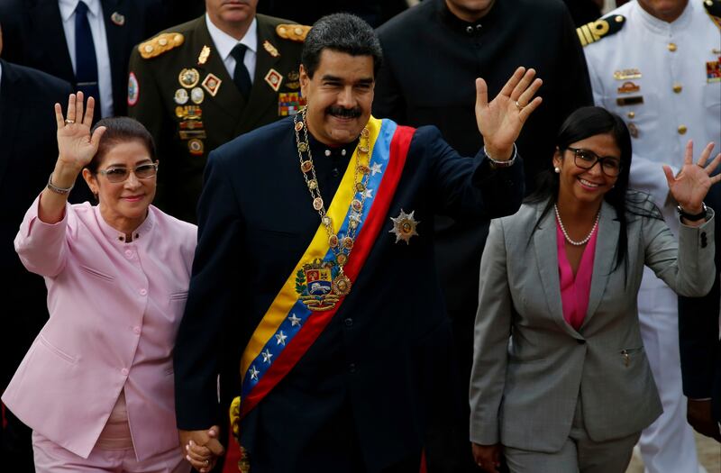 Venezuela's President Nicolas Maduro, center, with his wife Cilia Flores, left, and Constitutional Assembly President Delcy Rodriguez wave as they arrive to the National Assembly building for a session of the constitutional assembly in Caracas, Venezuela, Thursday, Aug. 10, 2017. The new constitutional assembly has declared itself as the superior body to all other governmental institutions, including the opposition-controlled congress. (AP Photo/Ariana Cubillos)