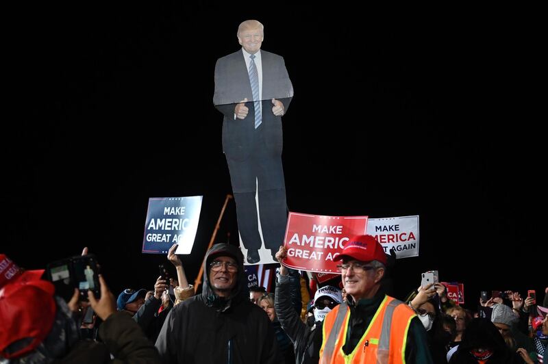 Supporters of US President Donald Trump hold a cutout of him at a rally to support Republican Senate candidates at Valdosta Regional Airport in Valdosta, Georgia.  AFP