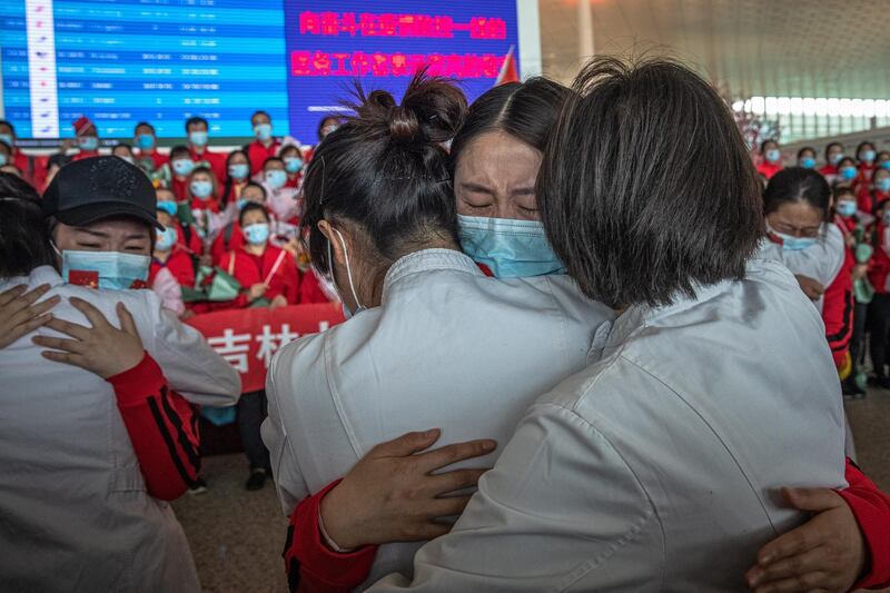 Medical workers from The First Bethune Hospital of Jilin University hug their Wuhan colleagues at the airport as they prepare to leave after the lockdown was lifted, in Wuhan, China.  EPA