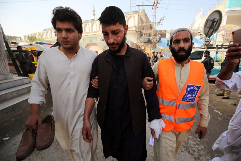 Rescue workers help an injured man in the aftermath of an explosion at an Islamic seminary in Peshawar, Pakistan.  EPA