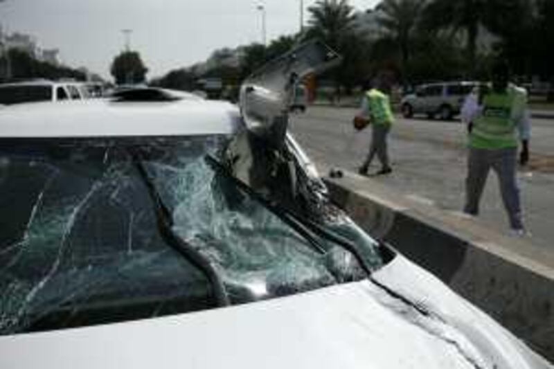 ABU DHABI, UNITED ARAB EMIRATES - February 8, 2009: Police clean up the scene of an accident, involving multiple cars at the corner of 15th Street and Airport Road in Abu Dhabi. 
( Ryan Carter/The National ) *** Local Caption ***  RC004-CarAccident.JPGRC004-CarAccident.JPG