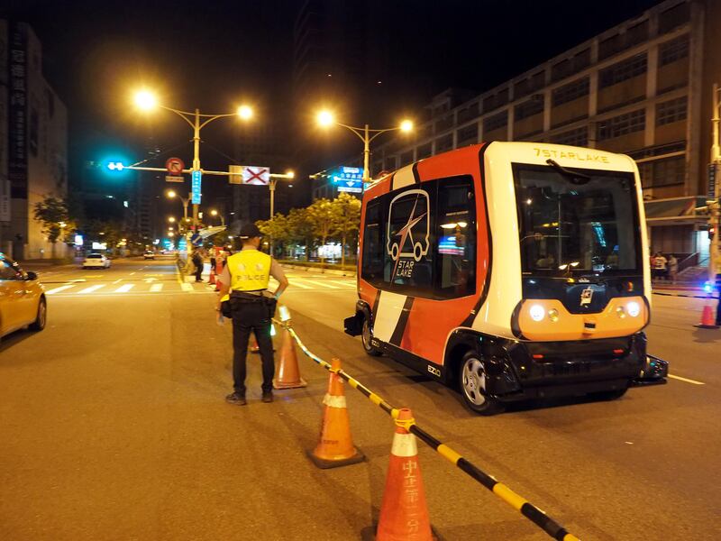 epa06119256 A policeman stands guard as a self-driving bus, EZ10, undergoes tests on a closed-off road in Taipei, Taiwan, 01 August 2017.The test will run from 1 am till 4 am for five days to allow the vehicle's computer to do mapping of the road and get familiar with road conditions and react to incidents. EZ10 can hold 12 passengers and runs on battery. With one charge, it can run at maximum 40 km per hour for 14 hours. The bus is made by French Easymile company and uses US-made light sensors and Taiwan-made computer system. Taiwan's 7Lakestar Co plans to launch the driverless bus in enclosed areas like industrial park, school campus or cultural center to serve as community bus or shuttle bus.  EPA/DAVID CHANG