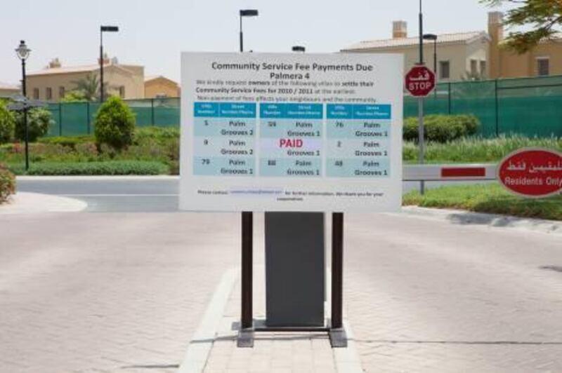 Dubai, United Arab Emirates - July 04 2012 - A sign posted outside of the entrance to Palmera 4 in Arabian Ranches lists the villa numbers who have not paid their Community Service Fees from 2010-2011. (Razan Alzayani / The National) 