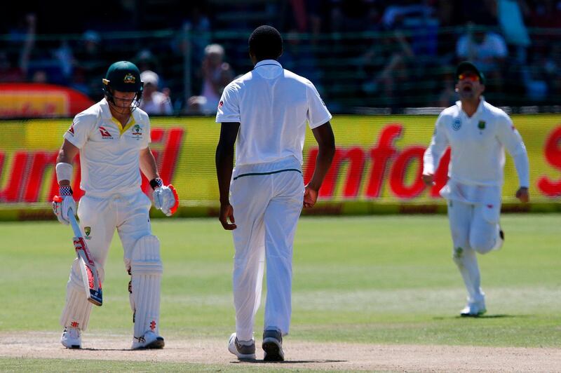 Australia's batsman David Warner (L) leaves the ground after having been dismissed by South Africa bowler's Kagiso Rabada (C) during day three of the second Test cricket match between South Africa and Australia at St George’s Park in Port Elizabeth on March 11, 2018. / AFP PHOTO / MARCO LONGARI