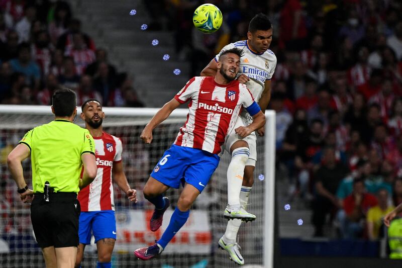 Atletico Madrid midfielder Koke and Real Madrid's Casemiro jump for the ball during a La Liga match in May, 2022. AFP