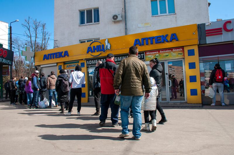 People queue at a pharmacy in Kharkiv. AP