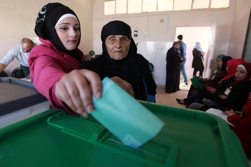 A woman helps her grandmother cast her ballot at a polling station in Amman January 23, 2013. Polling stations opened on Wednesday in Jordanian elections boycotted by the Muslim Brotherhood, which says the electoral system is rigged in favour of tribal areas and against the large urban centres. Eyewitnesses reported queues of about a dozen people apiece at several polling stations across the kingdom just before the polls opened at 7 a.m. (0400 GMT). REUTERS/Muhammad Hammad (JORDAN - Tags: POLITICS ELECTIONS) *** Local Caption ***  AMM56_JORDAN-ELECTI_0123_11.JPG