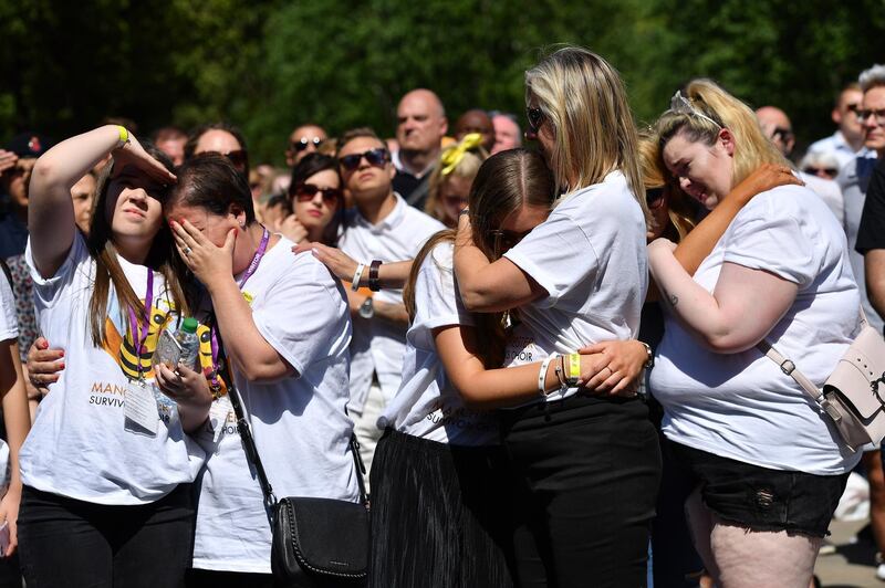 People hug as they observe one minute silence. Leon Neal/Getty Images