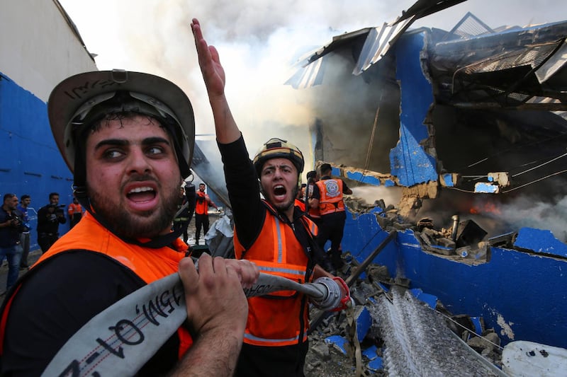 Palestinian firefighters at a factory in the northern Gaza Strip that witnesses say was hit by Israeli artillery shells. Reuters