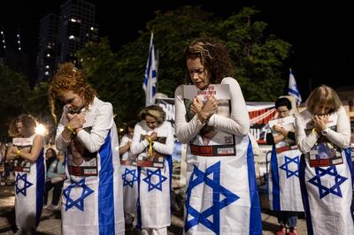 Women in Tel Aviv clutch photos of kidnapped and missing Israelis. Getty Images