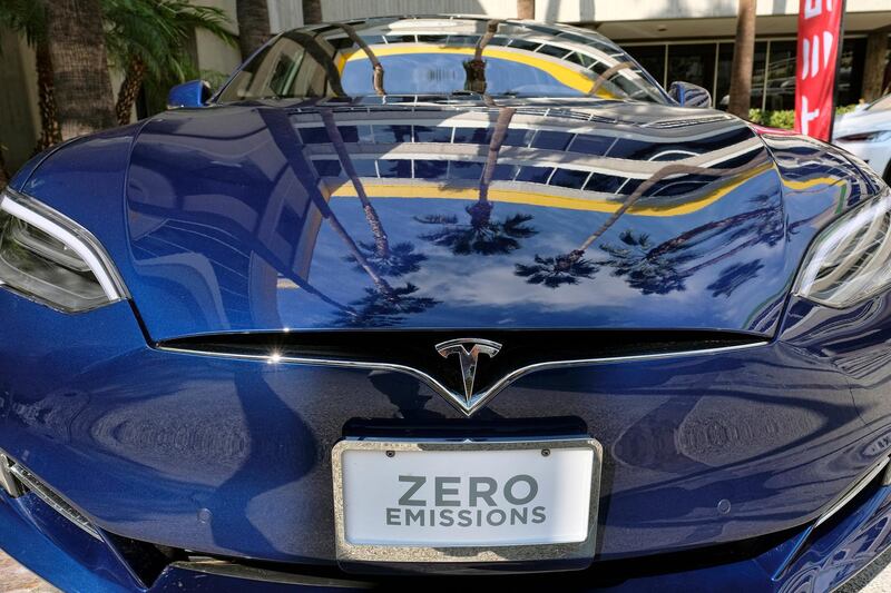 FILE - In this Oct. 24, 2016, file photo, palm trees are reflected on the hood of a Tesla Model S on display in downtown Los Angeles.  Tesla says it recorded one accident for every 3.34 million miles driven when the autopilot was engaged. 
That number of per-mile accidents rises to 1.92 million when autopilot is not on.  (AP Photo/Richard Vogel, File)