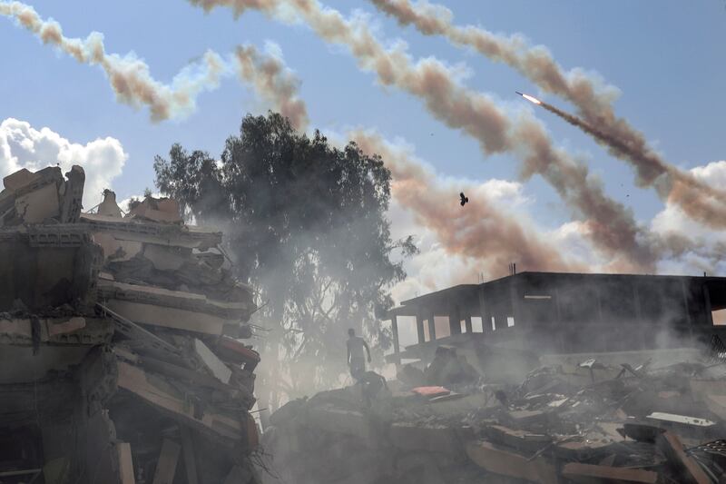 Rockets are fired from the Gaza Strip toward Israel over destroyed buildings following Israeli airstrikes on Gaza City. AP Photo
