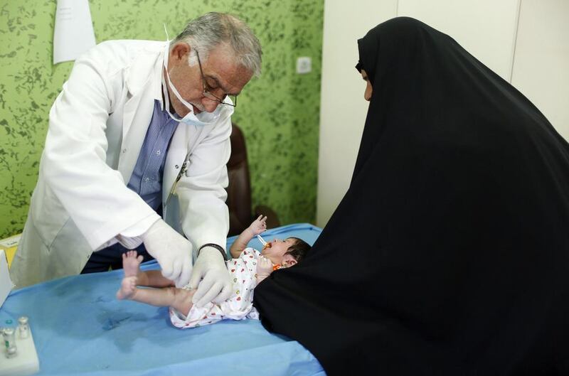 An Iraqi Shi’ite doctor vaccinates a baby at a clinic in Sadr City.