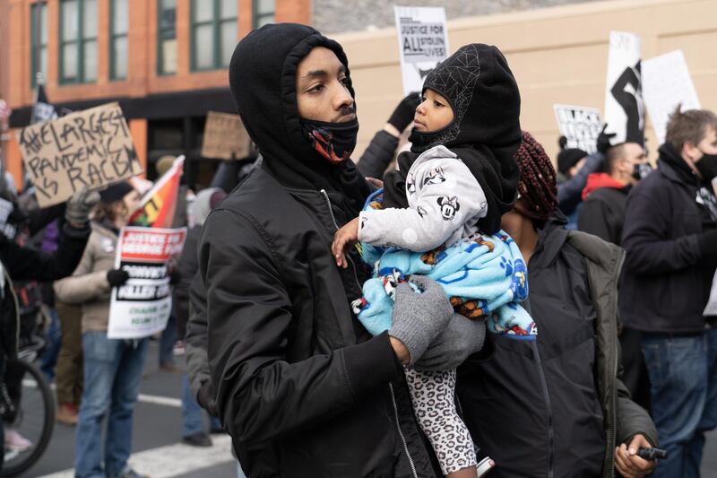 Protester Deven holds his one-year-old daughter Nevaeh at a protest in downtown Minneapolis. Willy Lowry / The National