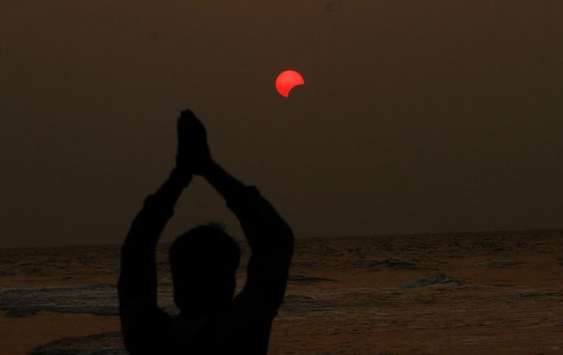 A fisherman prays to a partial solar eclipse seen in the sky over the Bay of Bengal in Konark.  Biswaranjan Rout / AP Photo