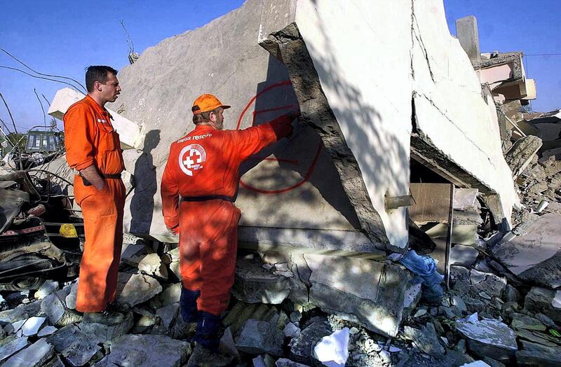 Members of a Swiss rescue team make markings on a wall of building in the town of Bhuj, 29 January 2001, that was destroyed in the massive 7.9 magnitude earthquake that struck northwestern India 26 January. The Swiss team is part of a larger international contingent helping out local relief work. An estimated 20,000 people are thought to have been killed in the quake, the worst to hit India for 50 years.     AFP PHOTO/Arko DATTA (Photo by ARKO DATTA / AFP)