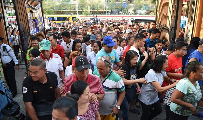 Voters rush inside as the gate opens at a polling station in Manila.  AFP
