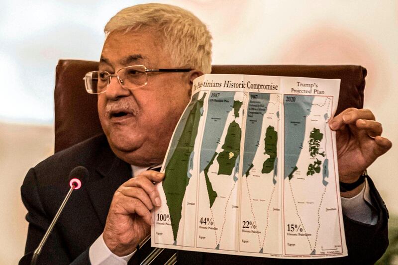 Palestinian president Mahmud Abbas holds a placard showing maps of (L to R) historical Palestine, the 1947 United Nations partition plan on Palestine, the 1948-1967 borders between the Palestinian territories and Israel, and a current map of the Palestinian territories without Israeli-annexed areas and settlements, as he attends an Arab League emergency meeting discussing the US-brokered proposal for a settlement of the Middle East conflict at the league headquarters in the Egyptian capital Cairo on February 1, 2020.  / AFP / Khaled DESOUKI
