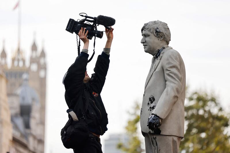 A cameraman homes in for a close-up of the oil-splattered statue. AFP