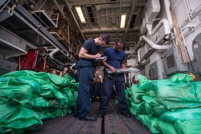 Ensign Sean Standard and Logistics Specialist 2nd Class Ray Sanders take inventory of a cache of over 1,000 AK-47 automatic rifles in the hangar bay of the guided-missile destroyer USS Jason Dunham, seized from a traditional dow, or sailing vessel in the Gulf of Aden, August 28, 2018. Picture taken August 28, 2018.  Mass Communication Specialist 3rd Class Jonathan Clay/U.S. Navy/Handout via REUTERS   ATTENTION EDITORS - THIS IMAGE WAS PROVIDED BY A THIRD PARTY