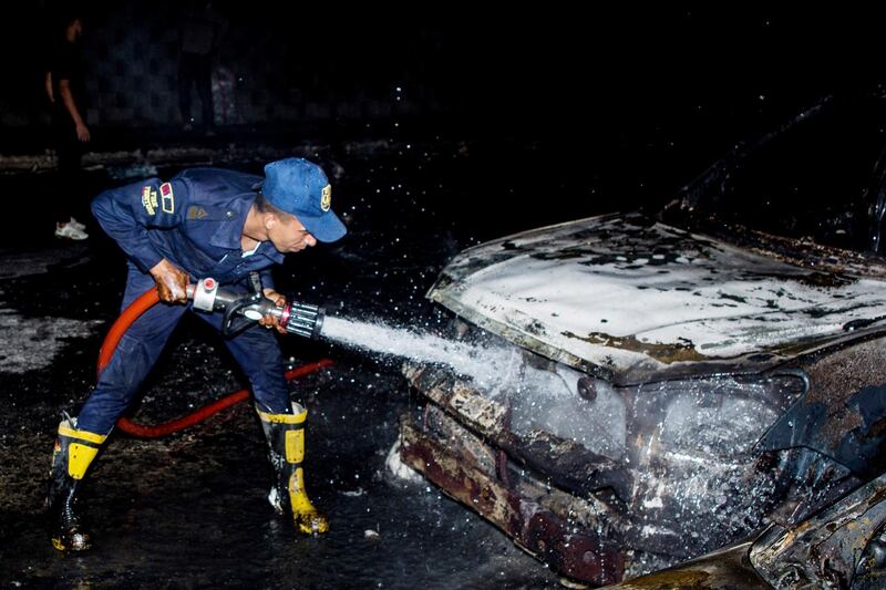 A firefighter hoses down burned vehicles following a fire that broke out in the Shuqair-Mostorod crude oil pipeline, on the Cairo-Ismailia road, in Egypt. A ruptured crude oil pipeline set off a monstrous blaze on a desert highway in Egypt on Tuesday, injuring at least 17 people, local authorities said. AP Photo